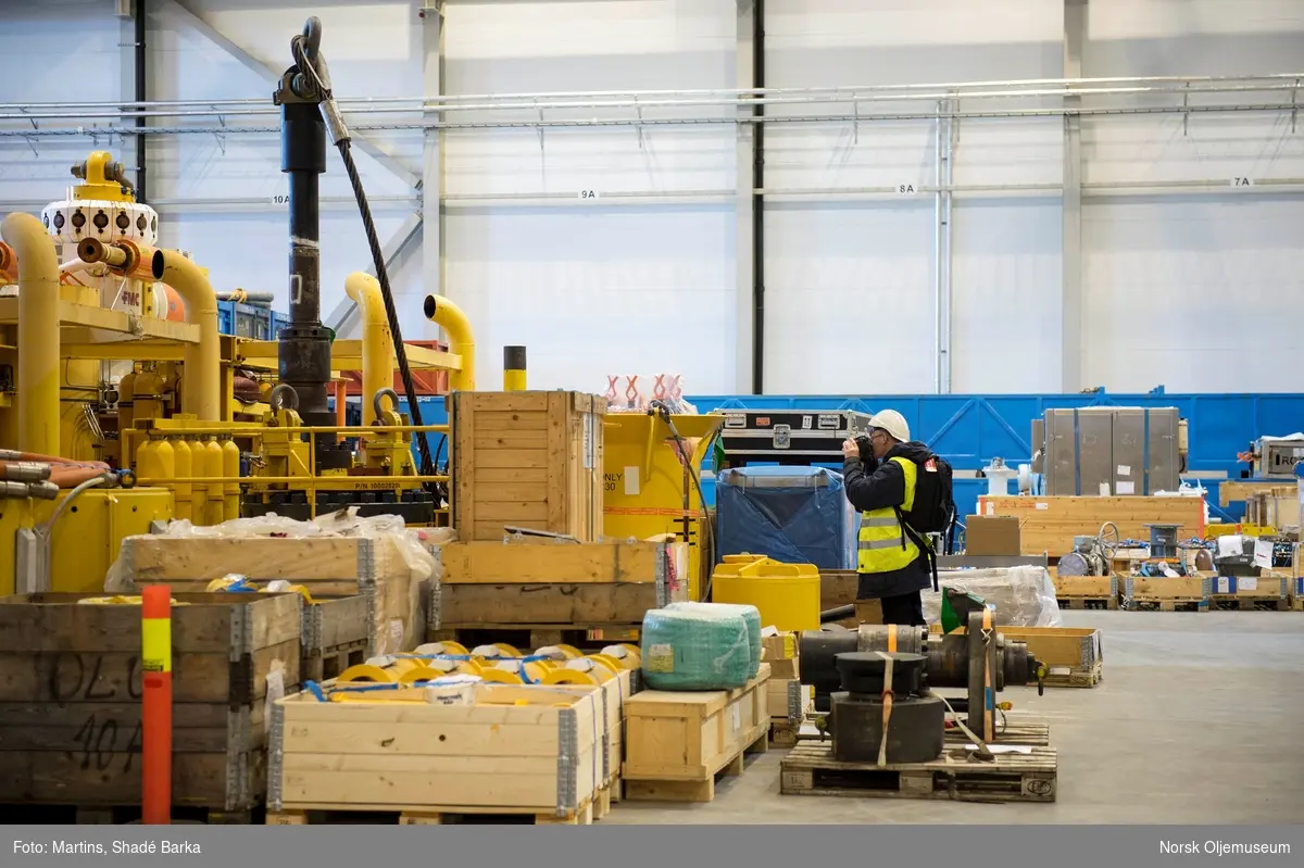 I det nye lagerbygget som stod klart i 2015 lagres diverse utstyr for subsea-virksomheten til Shell. Her står fotograf Jan A. Tjemsland, fra Norsk Oljemuseum og fotograferer diverse duppeditter.