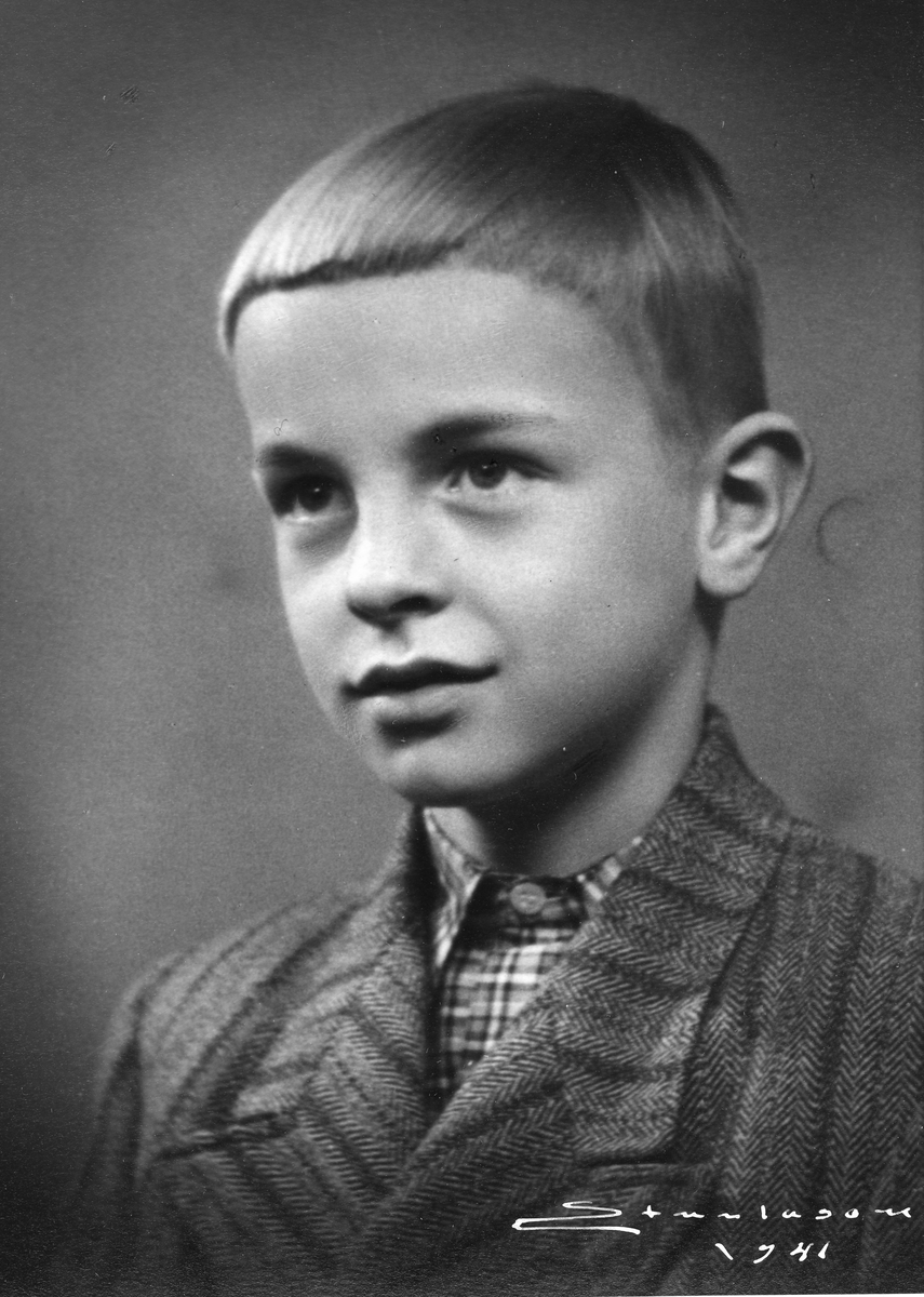 Portrett av ung gutt. Han har tweed-jakke og rutete skjorte.