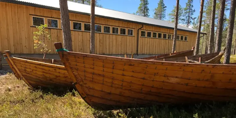 Gamle som står ute på Blokkodden med magasinhallen i bakgrunnen.