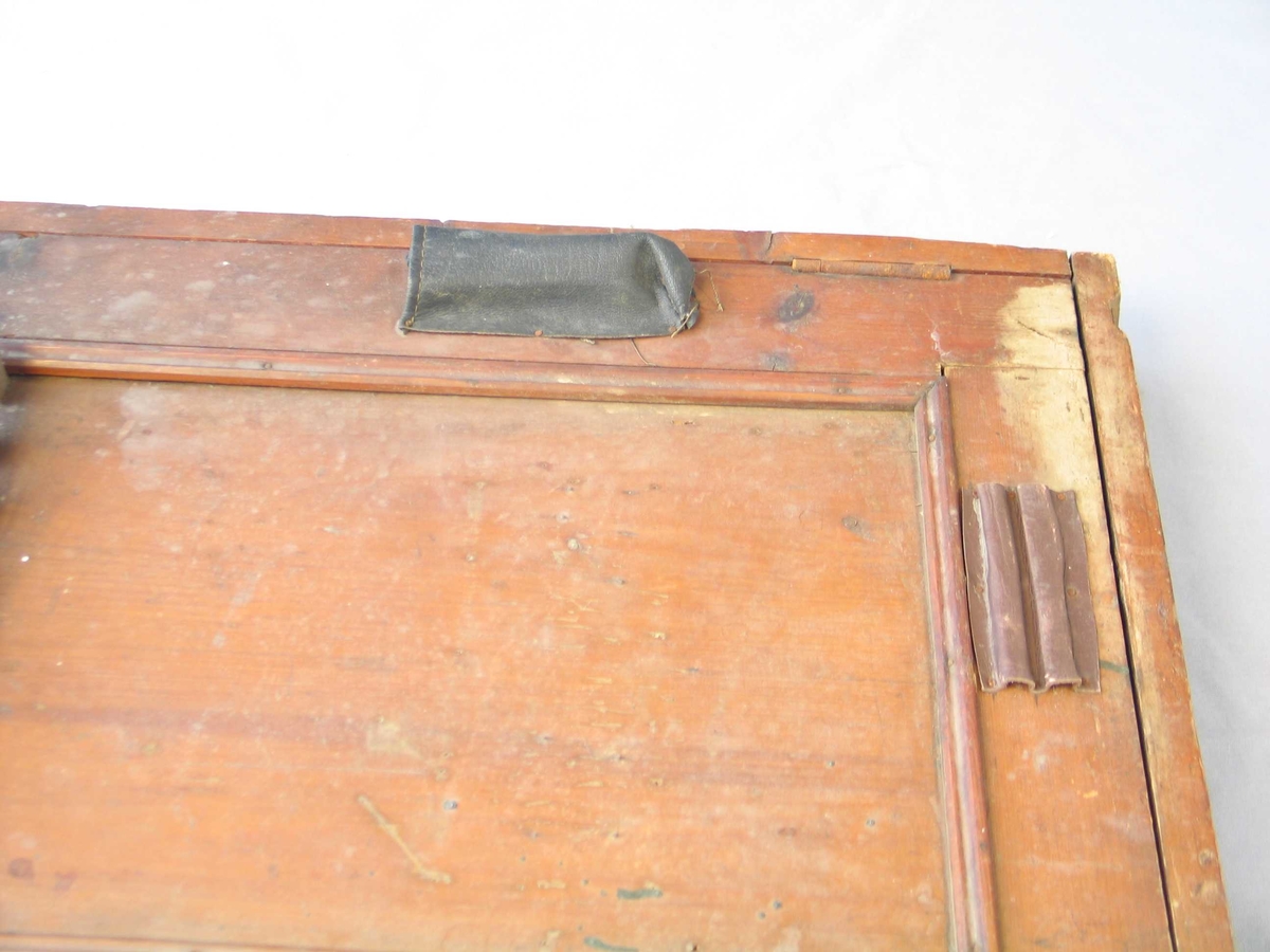 Rektangulær kasse med hengsla lok. Innvendig og utvendig opphengsordningar til  av verktøy. Brunbeisa