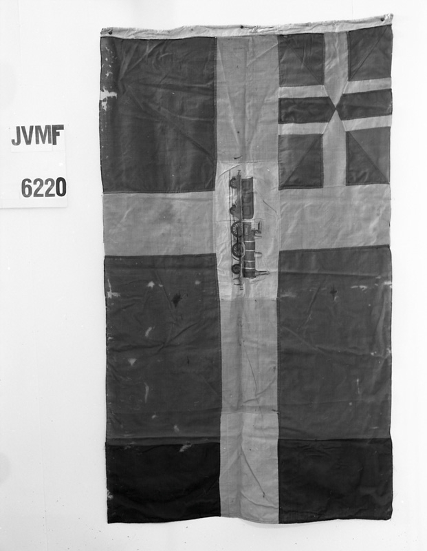 Oflikad unionsflagga med nät. Med lokbild med tender, svart nät.

Stationsflagga med unionsmärke (sillsalladen) i övre vänstra hörnet, samt lokbild med tender i mitten, mörkblå, röd, gul, med svart nät.