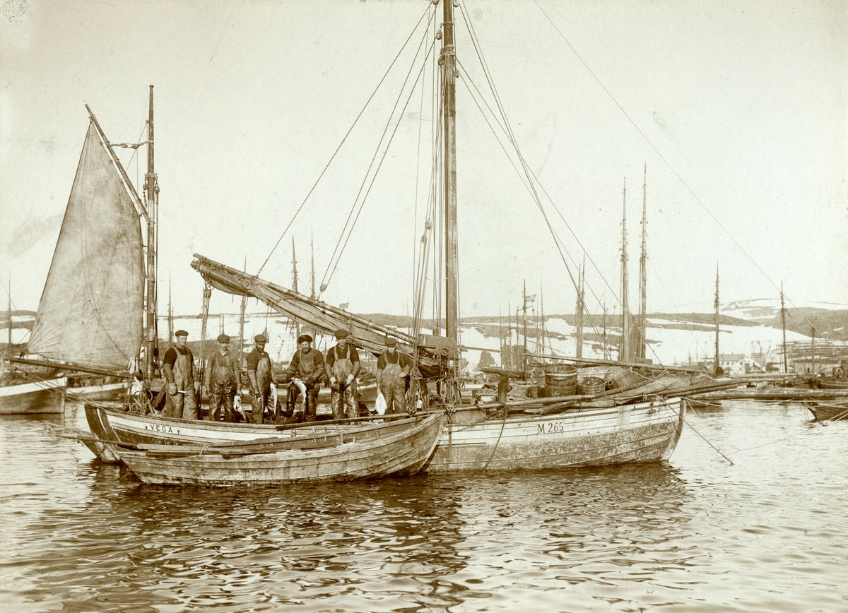 Båten "Vega", kjøpt av Jentoft Strand og Normann Angell i 1912. Bildet er tatt i Mehamn i Finnmark. Med på bildet er: Bernhart Selnes, Normann Angell, Fredrik Larsen, Rikart Olsen, Konrad Johnsen, Jentoft Strand.
