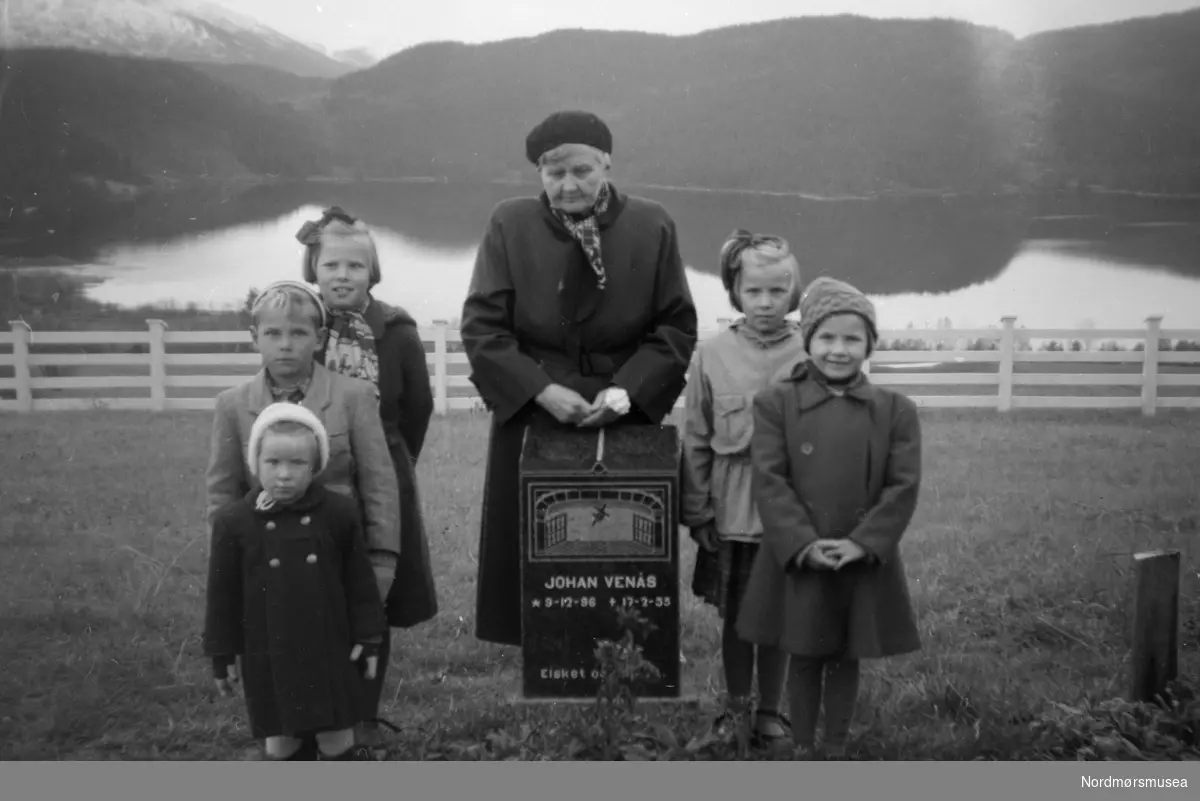 Familiefoto fotografert trolig fra Tingvoll kirkegård, mest trolig i 1955. En fotosamling fra slekten Røv på Meisingset i Tingvoll kommune. Fotografiene kan trolig dateres mellom 1950-1960. Eier av originalmaterialet er Jan Harry Røv. Fra Nordmøre museums fotosamlinger.