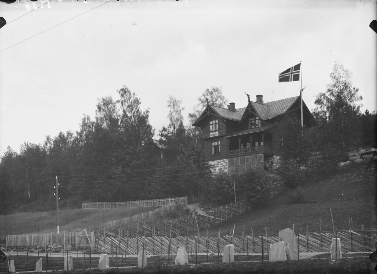 07.08.1900. Fronheim. Bolighus med skilt: HH Lie FOTOGRAF, flagg, gjerder. Fotograf Hans H. Lies bolig på Vinstra