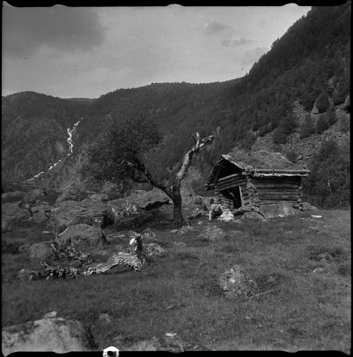 Bilder av familien Skjold fra Sauda i en hage og Oddvar Skjold som gutt på tur ved flere hytter og jettegryter i fjellet.