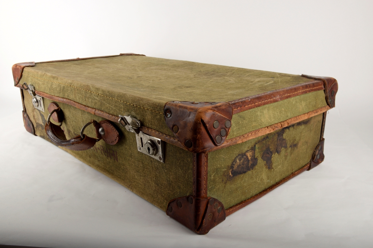 Rektangulær koffert av seilduk. Kofferten har to spenner til låsing på fremsiden og bærehank.