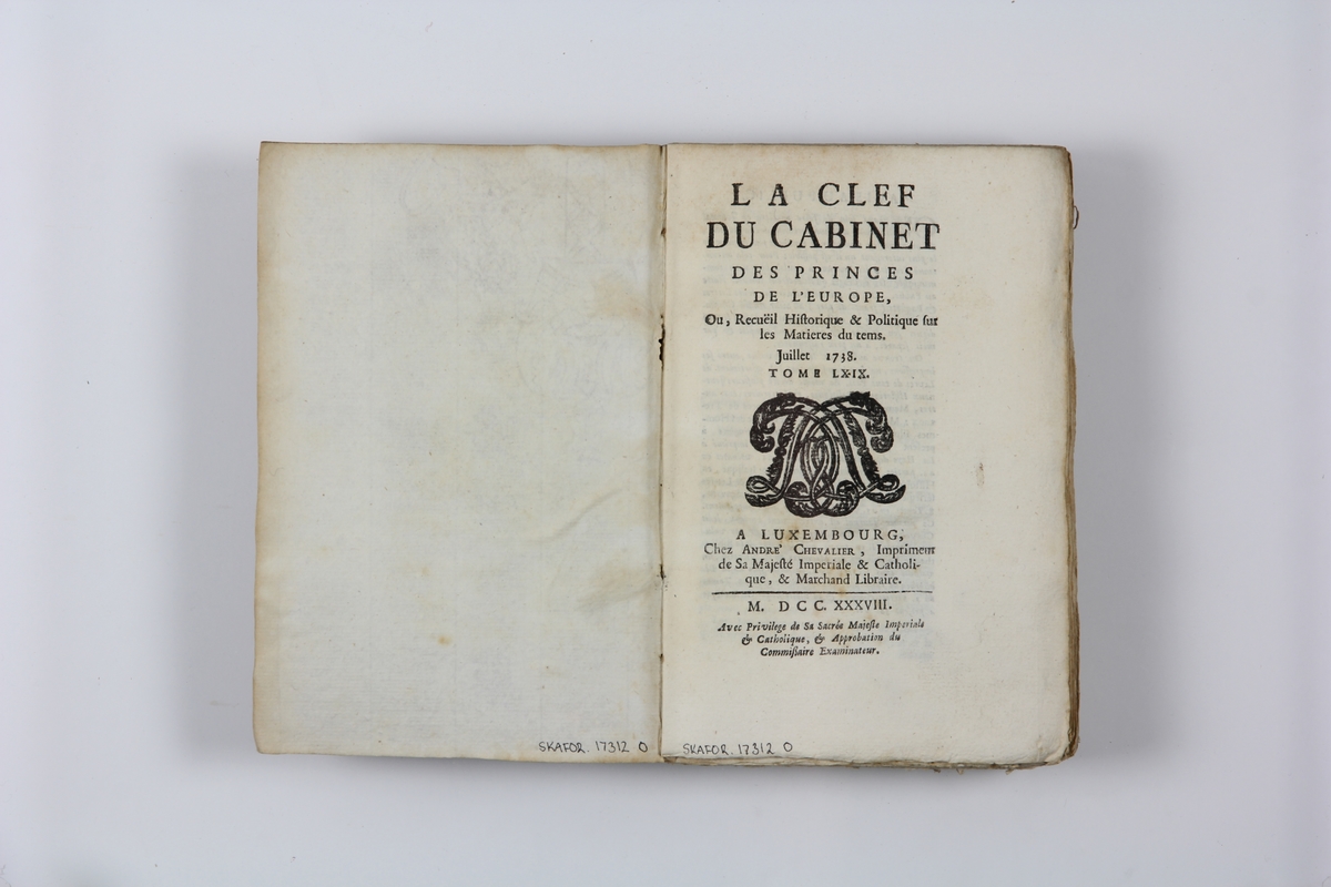 Bok, pappband "La clef du cabinet des princes de
 l´Europe", del 69, tryckt i Luxemburg 1738.
Marmorerat band med blekt rygg, påklistrade pappersetiketter med titel och volymens nummer. Med skurna snitt.