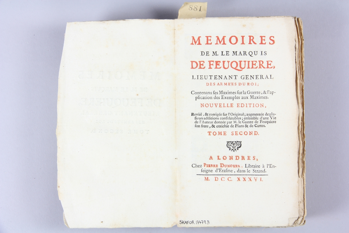Bok, pappband, "Mémoires de M. le marquis de Feuquière", del 2, tryckt 1736 i London. Pärmar av marmorerat papper, blekt rygg med etikett med volymens namn (oläsligt) och samlingsnummer. Oskuret snitt. Med kartor och planer.