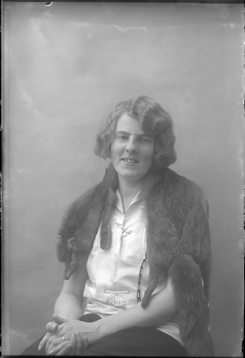 Porträtt av Lizzie Skoglund med vit blus och en räv om axlarna.