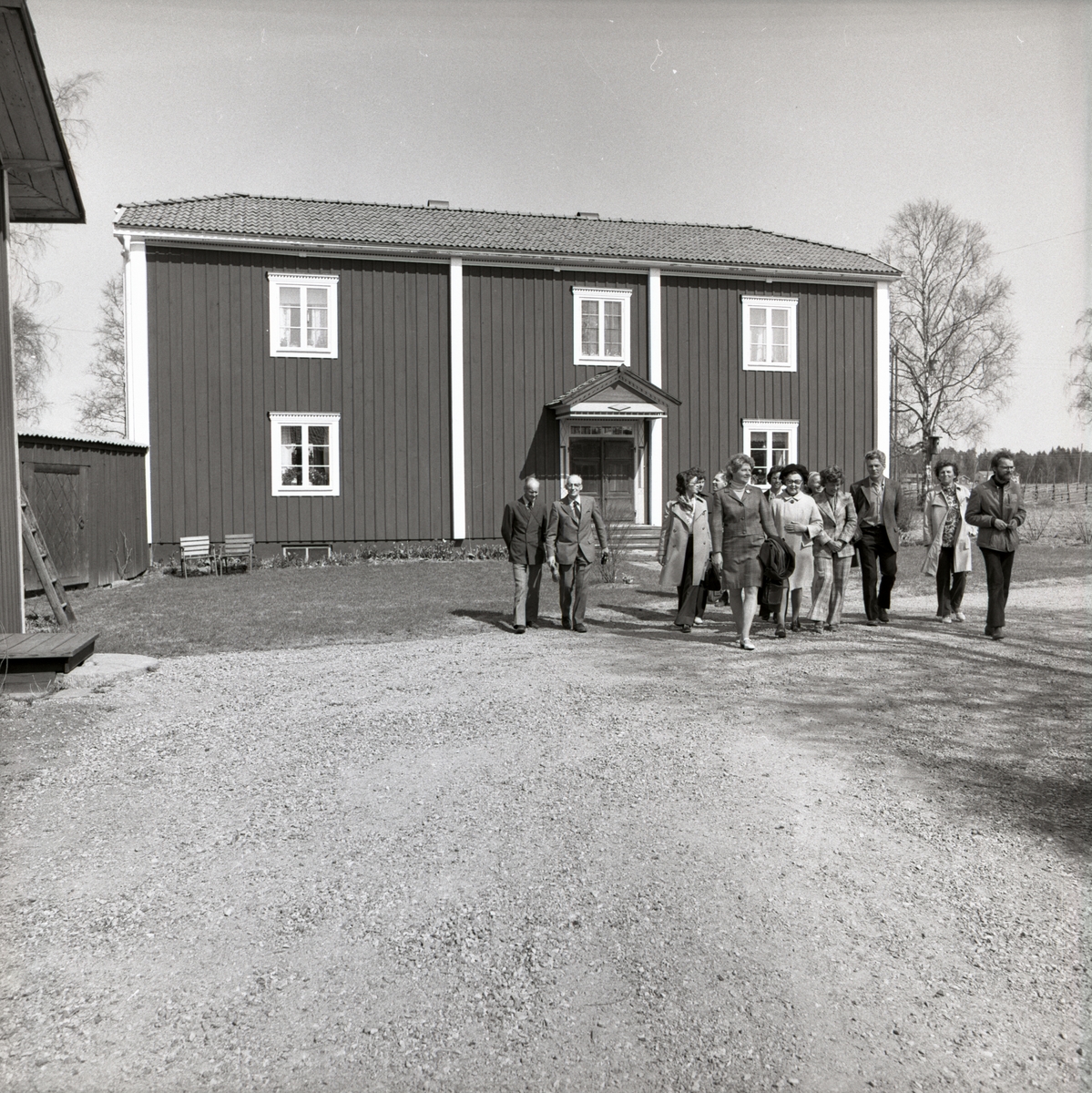 En grupp männniskor går över gårdsplanen vid gården Sunnanåker, 1974.