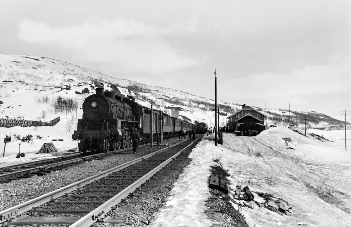 Påsketog retning Bergen, tog 7683, i spor 2 på Haugastøl stasjon. Toget trekkes av damplokomotiv type 31b nr. 428. Kryssende tog skimtes i spor 1.