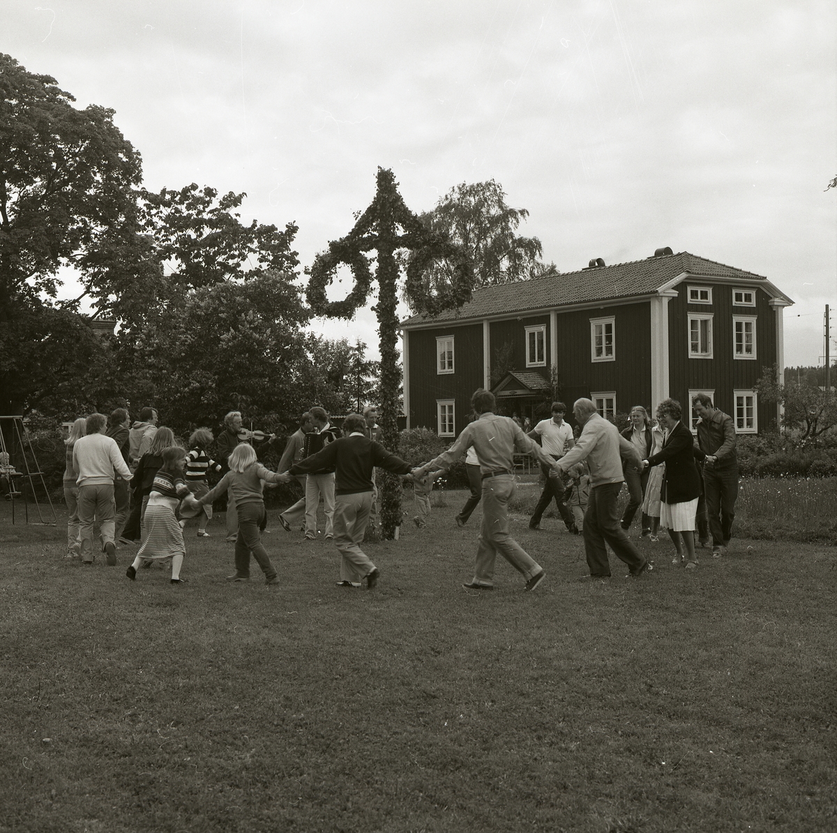 48 personer dansar runt stången vid ett midsommarfirande på gården Sunnanåker den 20 juni 1981.