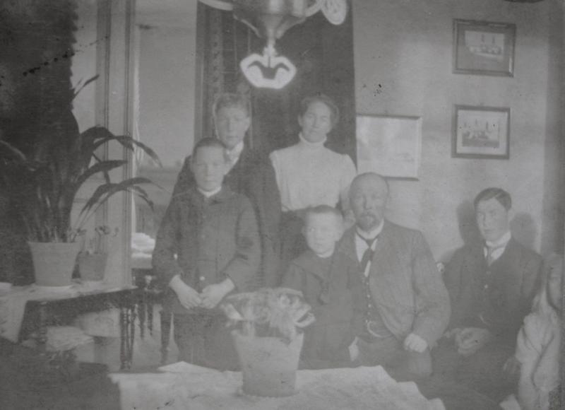 Dette bildet av familien Wang er tatt i stuen på Wanggården. Foran ser vi Asbjørn, Sverre, Anders, Einar og Anne som ikke har kommet helt med på bildet. Bak ser vi Ragnvald og Karoline.