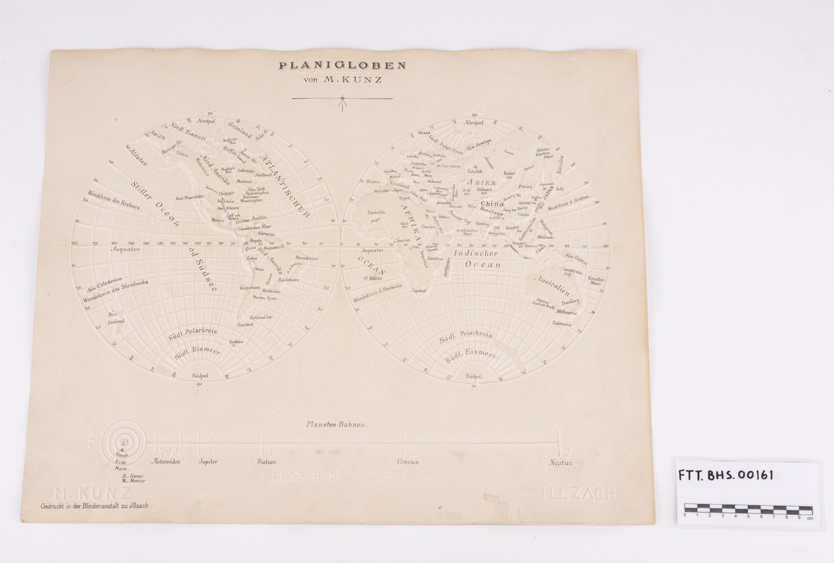 Taktilt kart av tykt papir som viser jordkloden og solsystemet. Kartet og noe av teksten er presset på papiret. Det er både punktskrift og bokstaver.
