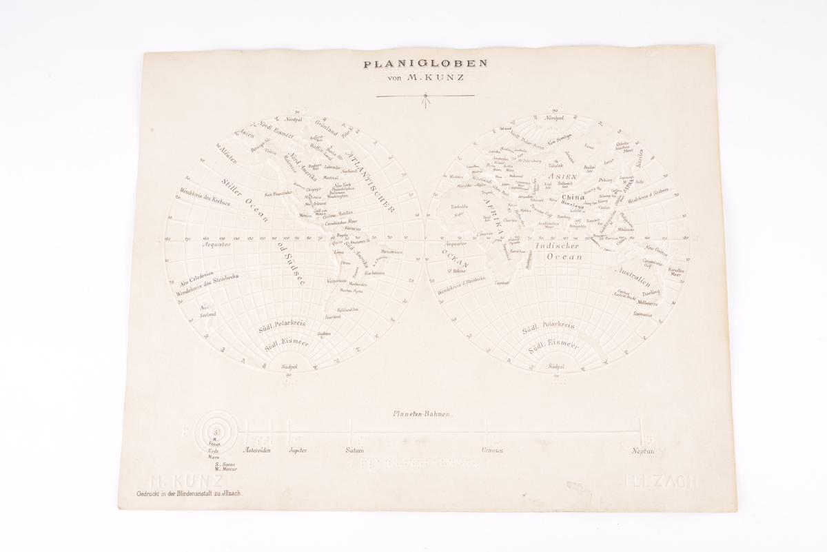 Taktilt kart av tykt papir som viser jordkloden og solsystemet. Kartet og noe av teksten er presset på papiret. Det er både punktskrift og bokstaver.
