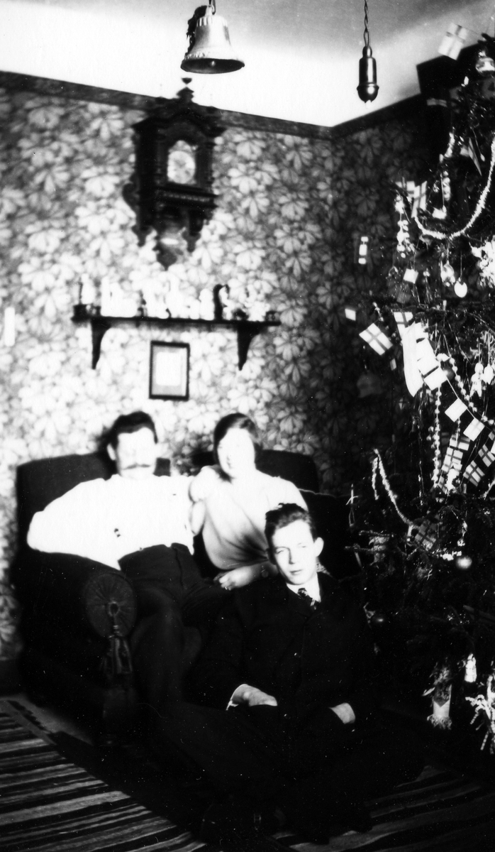 Suddig bild på en familj som sitter vid sin julpyntade gran.