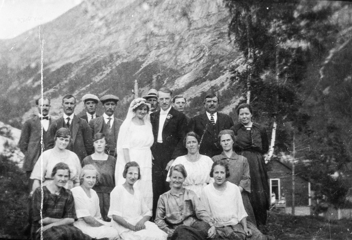 Brudeparet Louise Green og Carl Gustav Johansson saman med bryllupsgjester avbilda ved "Brakkebyen" ovanfor Kvernhusteigen