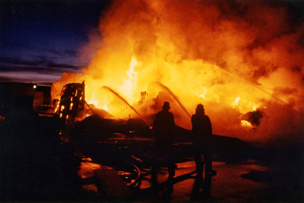Fra brannen i trelasttørka på Våler Skurlag på Braskereidfoss i Solør i 1979.  Bildet viser to brannmenn som stod og sprøytet vann inn i flammehavet.

Materialtørkinga ved sagbruket på Braskereidfoss foregikk lenge i strølagte stabler på sagbrukstomta, altså i friluft.  Stablinga var arbeidskrevende og tørkinga tok tid, det gikk med andre ord lenge fra tømmeret kom inn på sagbruket til trelasten kunne leveres kundene.  Produksjonsøkningen som kom da et nytt og langt mer effektivt sagbruk ble gjenoppbygd etter brannen i 1964 førte dessuten til at den tradisjonelle tørkemåten begynte å bli vel plasskrevende.  I 1968 fikk bedriftsledelsen mulighet til å bygge ei moderne trelasttørke, hvor man fikk en helt annen kontroll på tørkeprosessen enn tidligere.  Man gjorde seg umiddelbart gode erfaringer.  Kapasiteten ble deretter utvidet, først i 1969, deretter i 1971.