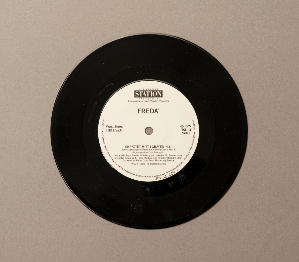 Singel-skiva av svart vinyl med vit pappersetikett, i omslag av papper. Framsidan av omslaget har ett färgfotografi av gruppen.

Innehåll
Sida A: Det måste gå
Sida B: Skrattet mitt i gråten

JM 55207:1, Skiva
JM 55207:2, Omslag
