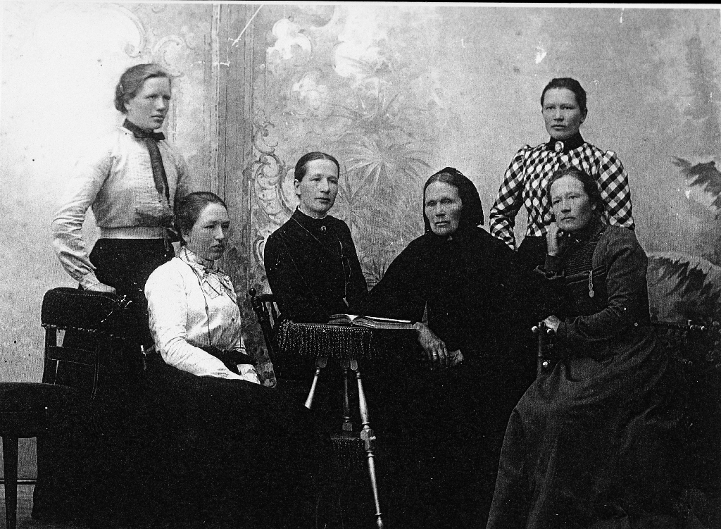 Berta Mossige f. Olsdtr. Lende (5.5.1842 - 28.10.1933 med døtrene sine. F. v. : ståande Berta Cecilia g. Austerå (3.6,1875 - 19.11.1965 budde på Kalberg n bnr. 2, Alvilde Mossige (30.9.1880 - ) g. Drange, budde i Fana, Karen Elisabeth Mossige (16.12.1865 - ) g. Thorsen, budde på Sandnes, Marta Dorthea (15.3.1871 - ) g. Kvia, budde på Sandnes, Anna Margretha Mossige (11.1.1869 - ), g. Gjesdal, budde i Gjesdal.