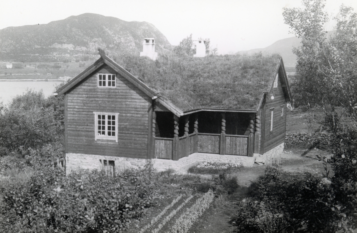 Prospektfotografi av et hus i sveitserstil med hage og skog rundt. Hjemmet til Ingvald Skjeldrup i Søvik. I bakgrunnen ser man en del av Terøya.