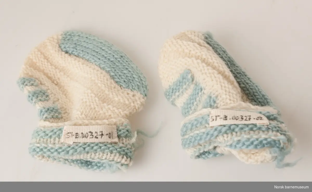 Hvit strikket sokk, med lyseblå detaljer.