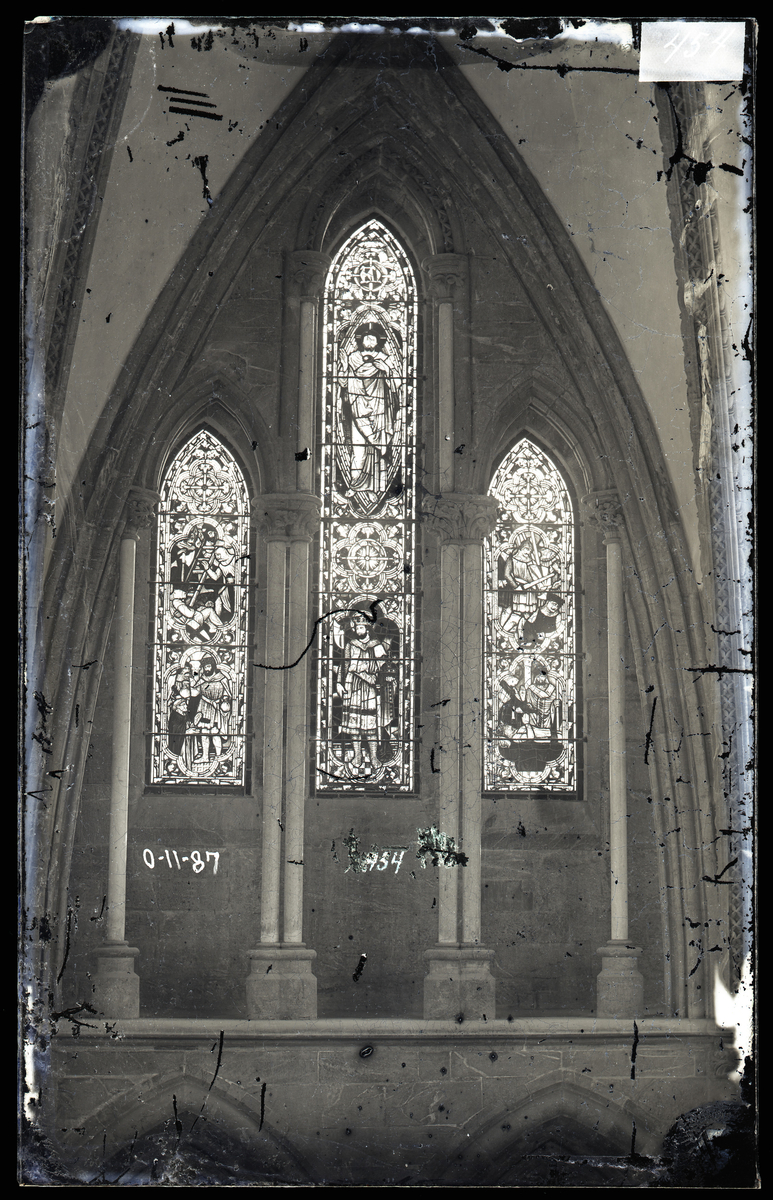 Glassmaleri i ambulatorium i oktogonen i Nidarosdomen, utført av James Powell & Sons. Kong Oscars gave. Kong Oscar II gav midler til restaureringsarbeid etter kroningen i Nidarosdomen i 1873. Vinduene var ett av prosjektene som pengene skulle gå til. Vinduene er senere byttet ut.