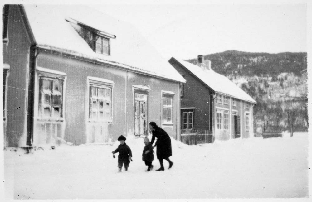 Kvinne og to barn i snøen i Holbergs gate. Lagmannsgata 6 til venstre. Jonas Lies gate 3 til høyre. Park til høyre bak, der det nå ligger eldreboliger (Hagen). Dolstadåsen sees bak.