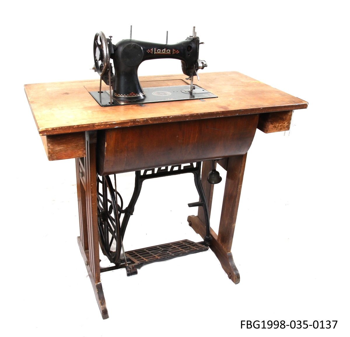 Symaskinbord med trømaskin, to låsbare skuffer til oppbevaring av sysaker. Symaskinen kan vippes ned i bordet.