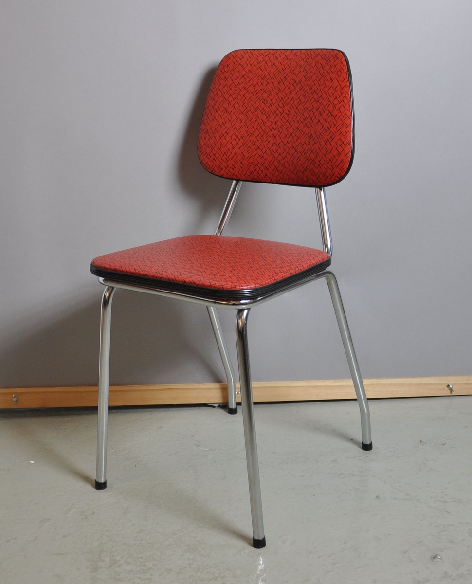 Kjøkkenstol med rødt trekk. Ryggstole og bein er av metall. Sete og rygg er trekt med gummi/skai.