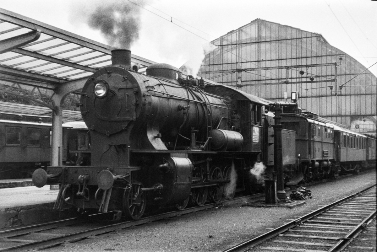 Damplokomotiv type 33a nr. 300 med persontog retning Voss, tog 618, på Bergen stasjon. Elektrisk lokomotiv type El 9 nr. 2063 medfulgte toget.