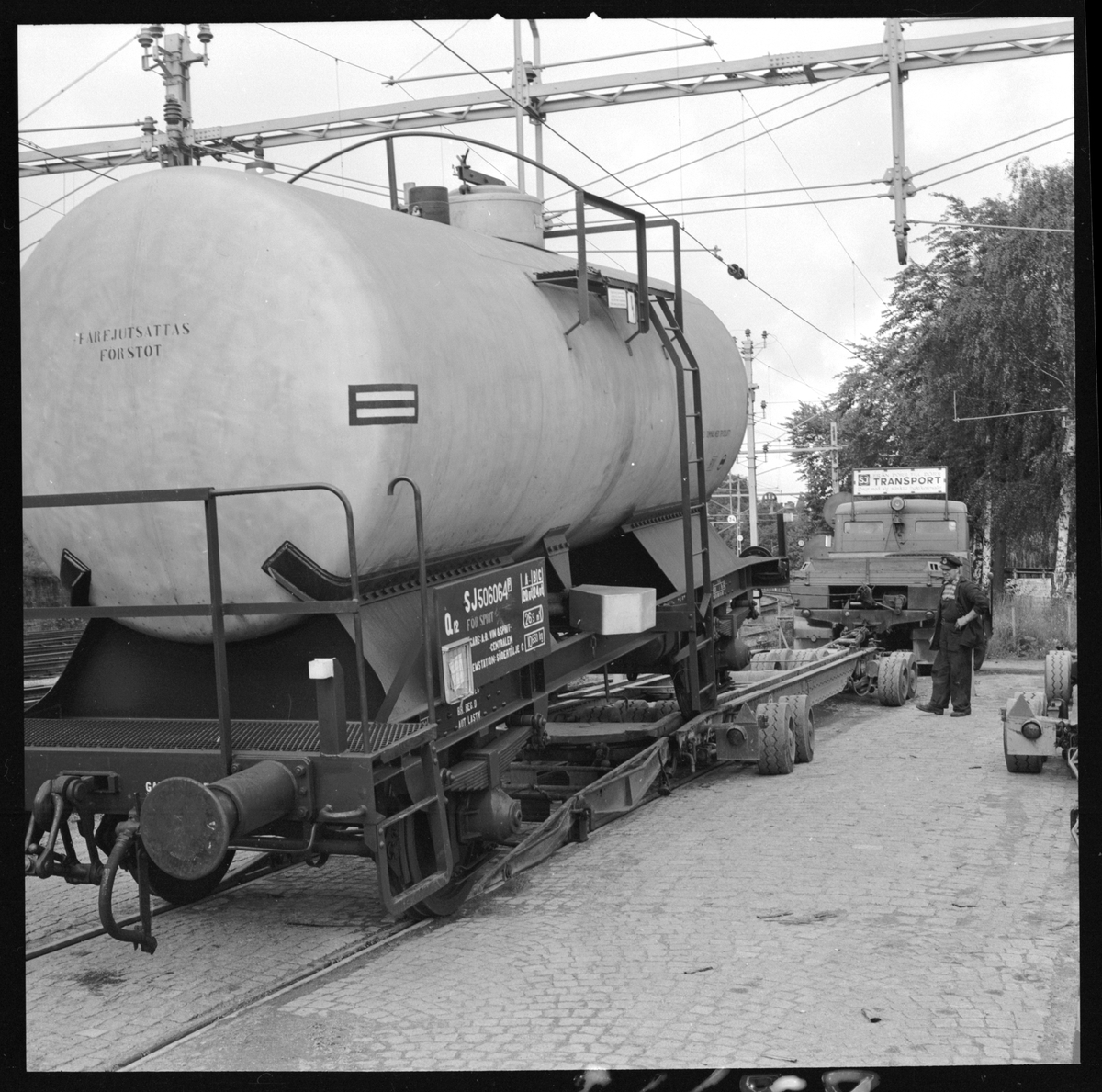 Statens Järnvägar, SJ Q12 506064 tankvagn. Vagnbjörn med dragfordon. Lastning av tankvagn.