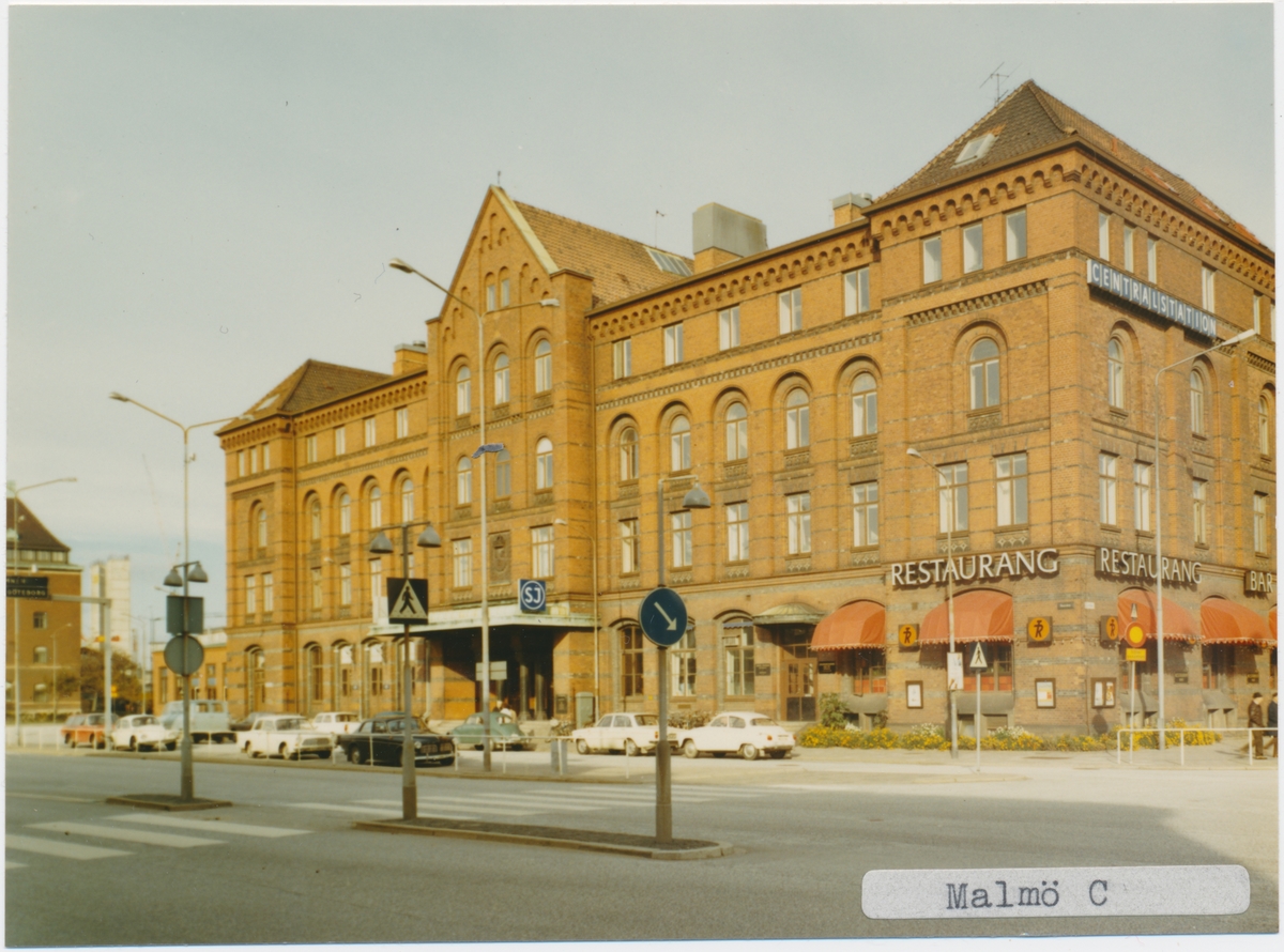 Malmö station 1971. Statens Järnvägar, SJ. Det första stationshuset invigdes 1856, men förstördes delvis i en brand 1866. Vid återuppbyggnaden kunde bara klocktornet bevaras och det andra stationshuset invigdes 1872. Med tiden anslöts fler banor till Malmö och det stora nya stationen med 4 nya spår blev klar 1891.1924 byggdes den nuvarande stationshuset. Banan elektrifierades 1933.
