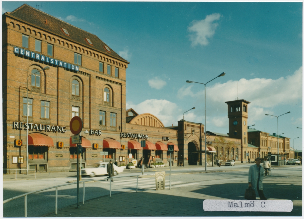Malmö station 1971.Statens Järnvägar, SJ. Det första stationshuset invigdes 1856, men förstördes delvis i en brand 1866. Vid återuppbyggnaden kunde bara klocktornet bevaras och det andra stationshuset invigdes 1872. Med tiden anslöts fler banor till Malmö och det stora nya stationen med 4 nya spår blev klar 1891.1924 byggdes den nuvarande stationshuset. Banan elektrifierades 1933.