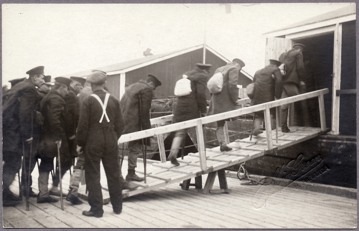 Transport med båt över Torne älv med ryska skadade krigsfångar i Haparanda under Första världskriget.