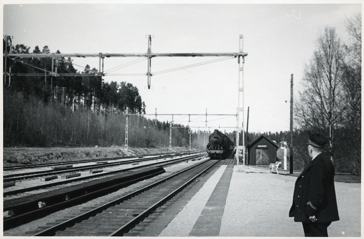 Stinsen väntar på ankommande ångtåg draget av ett Statens Järnvägar, SJ B-lok.