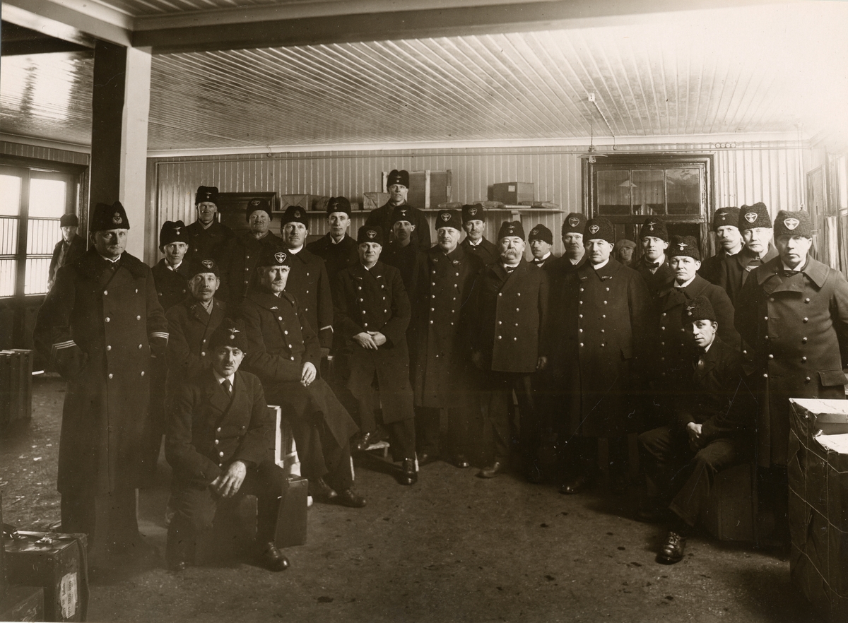 Personal vid Bollnäs station 1932. 26 anställda vid stationen är fotograferade i vinterkläder i godsmagasinet, Samtliga bär pälsmössor.