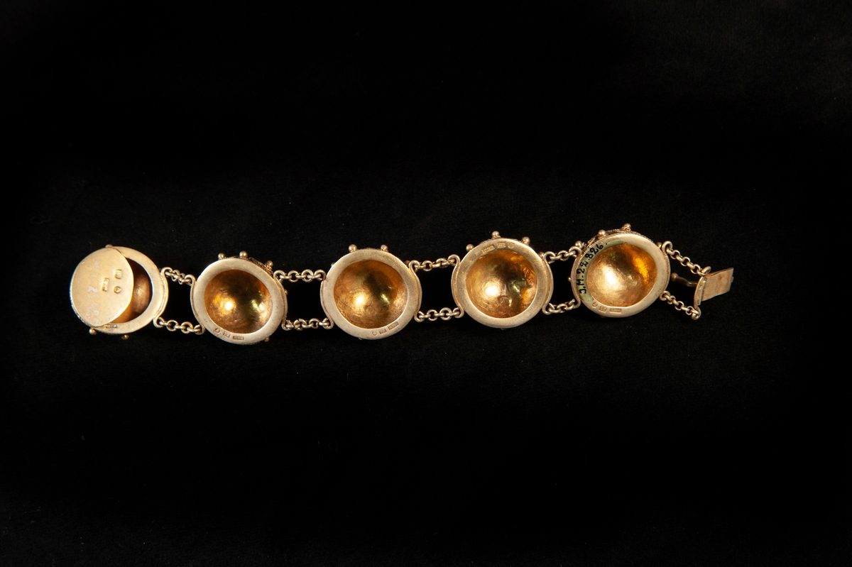 Ett armband av guld, bestående av 5 ihåliga halvklot, med filigranarbete i vikingastil på framsidan. Halvkloten är sammankopplade med dubbla kedjor. Enkelt sticklås. Varje halvklot är stämplat.