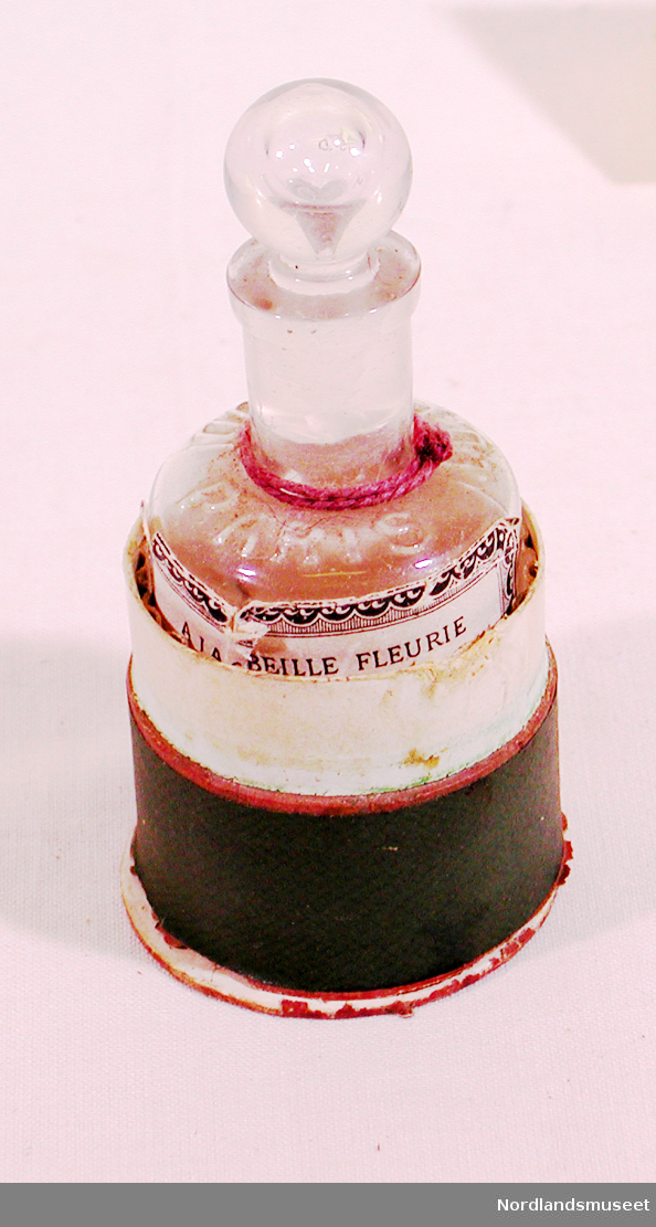 Form: Flaska: Sylinder,innoverb.skulder, glasskork. Beholder: Sylinder m/ lokk.
