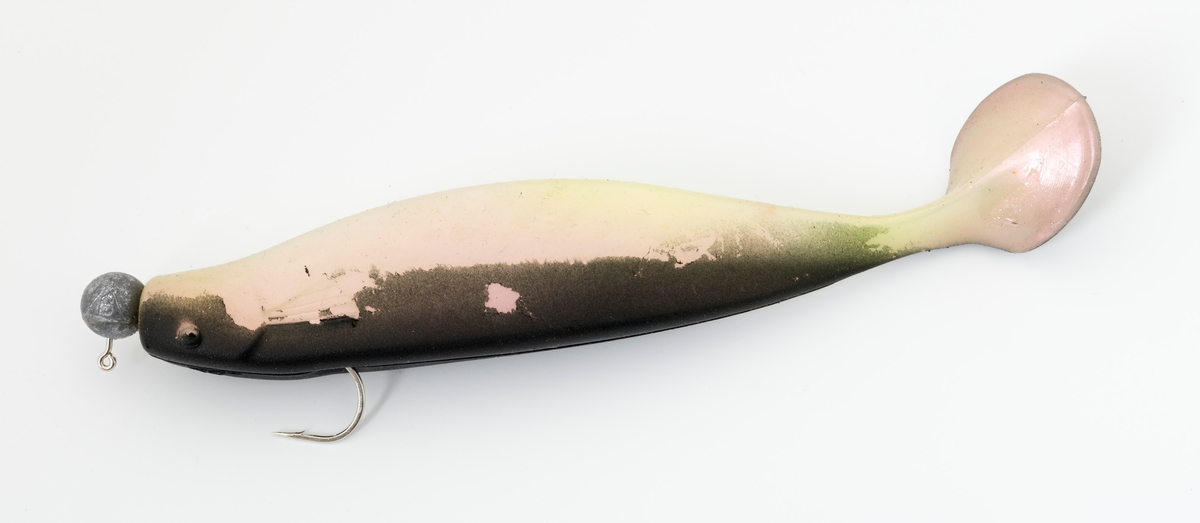 Jigg av gummi, muligens silikon, som er festet på en jiggkrok (jigghode). Kroken, enkeltkroken, som jiggen er festet til er langskaftet og utstyrt med et blyhode støpt fast til krokskaftet, som gir kastetyngde. Kroken stikker opp av ryggen på fiskekroppen.  Jiggen er en fiskimitasjon med flat, mørk hale, mørk rygg, lys side og underside med innslag av noe rosa og grønt. Denne jiggen kan defineres som en shadjig. I boka Sportsfiskeleksikon (2005) defineres shad som tradisjonell silikonjigg, en fiskeimitasjon med flat hale som skaper et svømmende inntrykk. 



Jiggen brukes til kastefiske med stang der spinnagnet imiterer attraktive byttedyr for fisken.