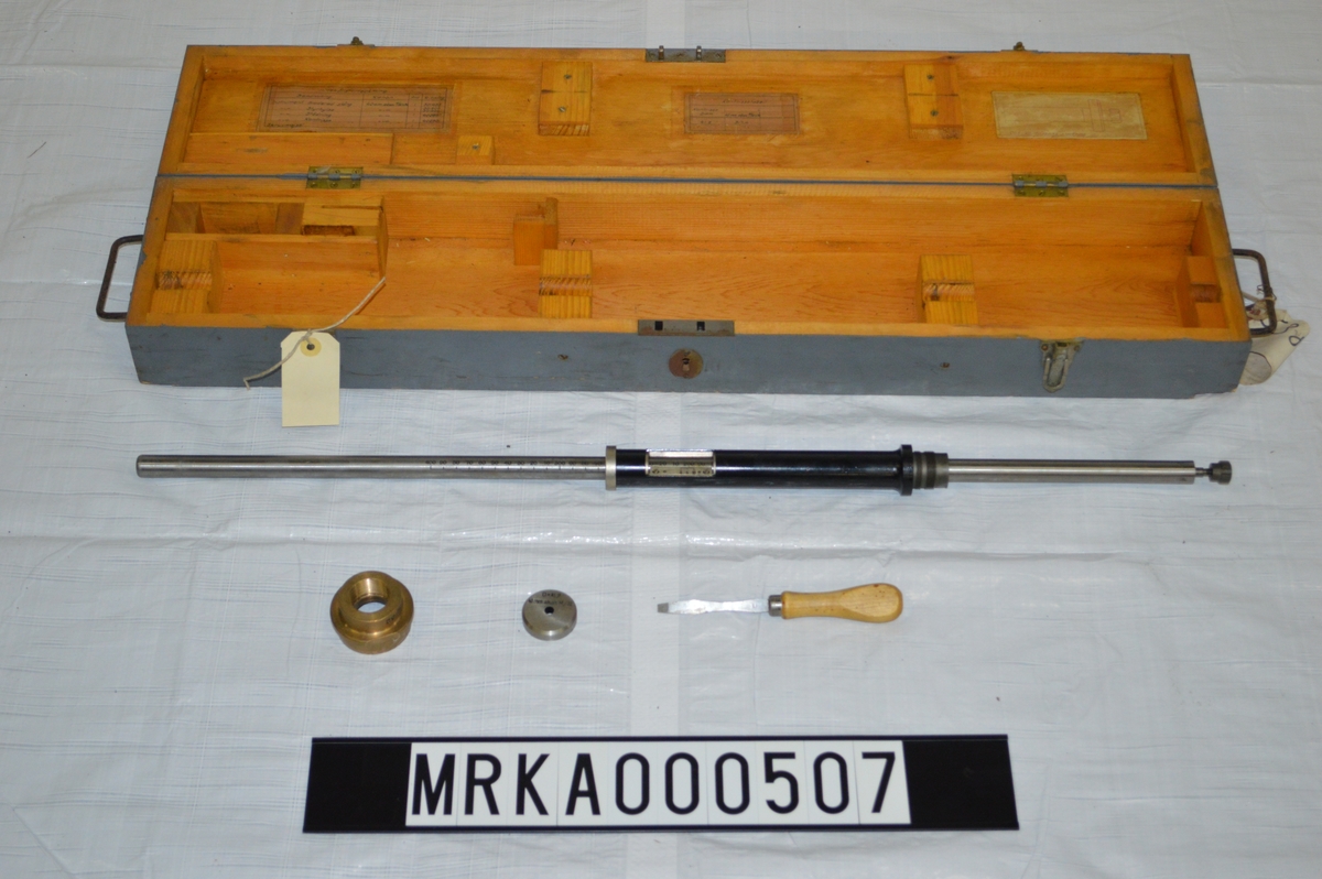 Kontrisseinstrumentet av metall.
Förvaringslådan av ek-trä.
Instrumentet användes för att mäta övergångskonens förskjutning, dvs eldrörets förslitning, vilket påverkade projektilens utgångshastighet (Vo).