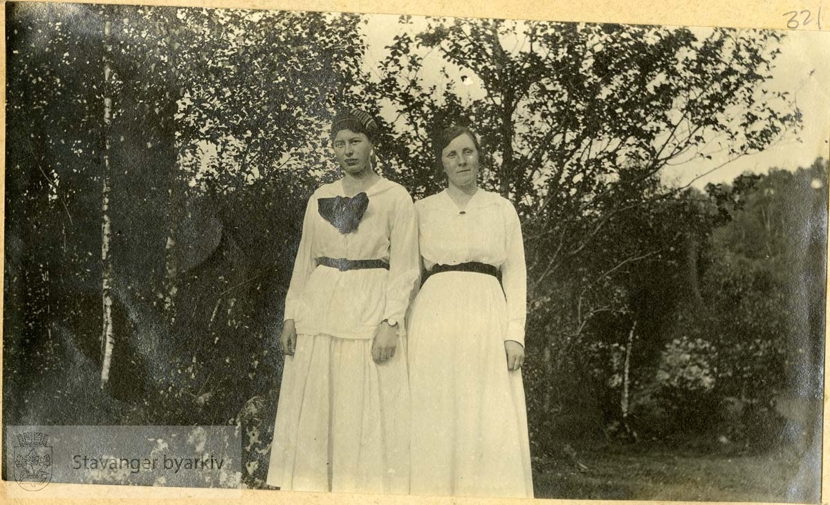 To damer, begge i hvitt med sorte belter