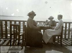 Tre kvinner nyter sin kaffe utendørs
