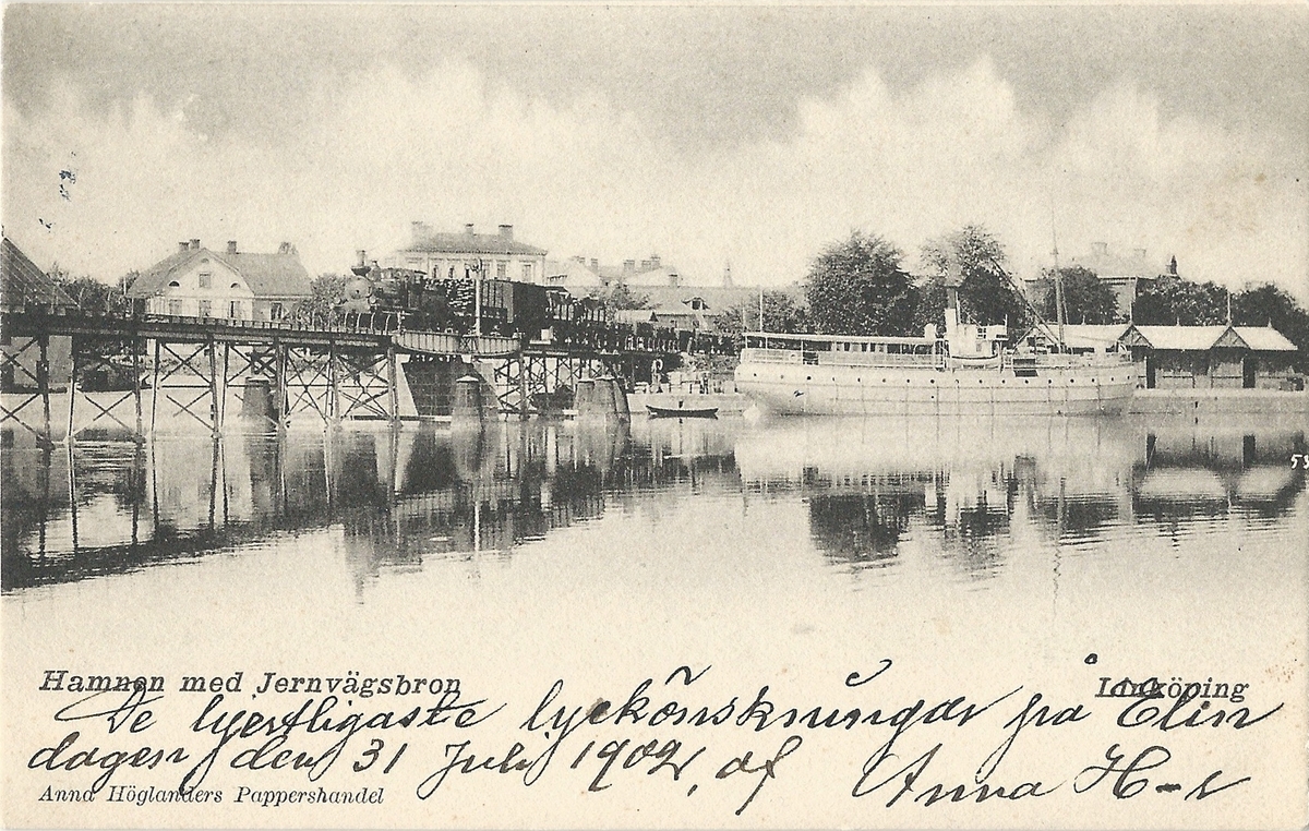 Vykort från  Linköping hamnen med järnvägsbron över Stångån.
hamnen, järnvägsbron från väster,tullkontor, ånglok, Kinda kanal, Stångån, fraktfartyg, 
Poststämplat 30 juli 1902
Anna Höglanders pappershandel