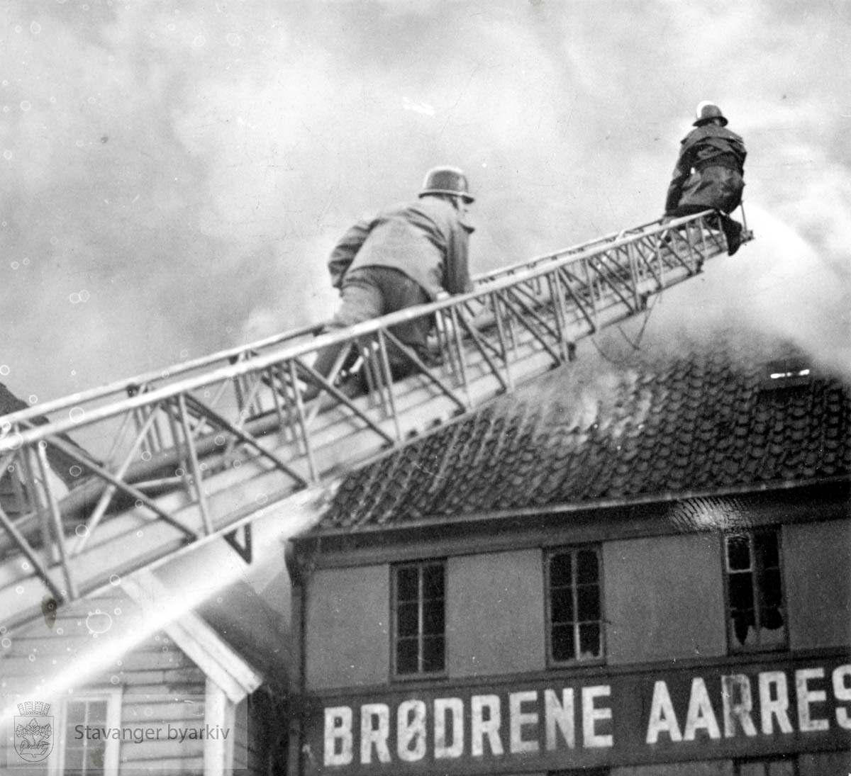 Brannmenn slukker brann fra brannstige.