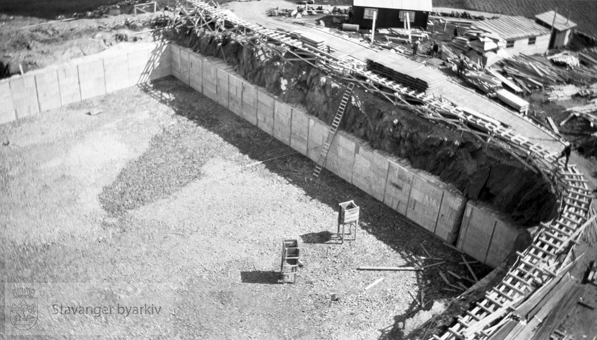 Forskaling og bygging av basssengveggene...Vann fra Store Stokkavatn ble pumpet opp til bassenget på Tjensvollhøyden 89 m o.h.Stokkavatnanlegget startet opp i 1930 og fra da stilnet pumpene i Egenes brannstasjon. Stokkavatnet var byens vannreservoar fram til 1959.