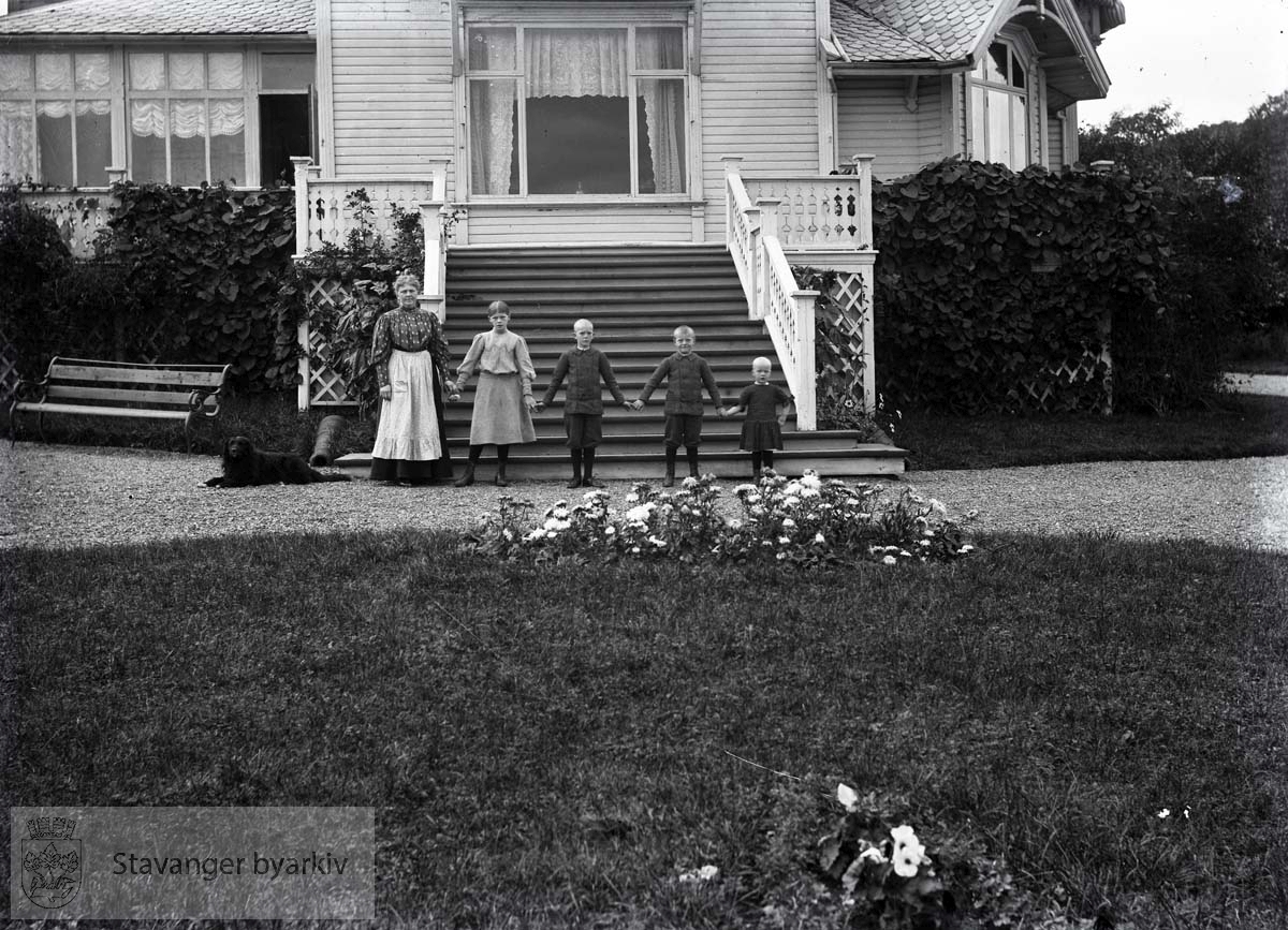 Martha Monsen og fire barn foran verandatrapp.