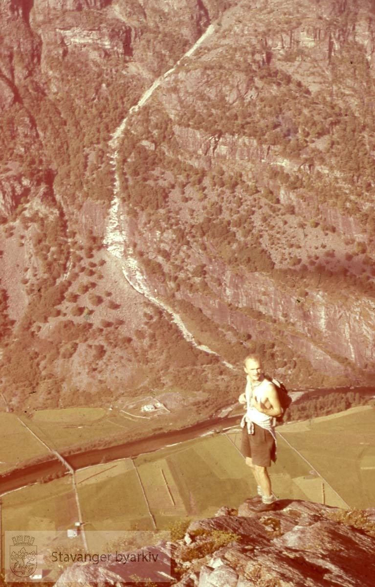 Person på fjelltopp foran dal