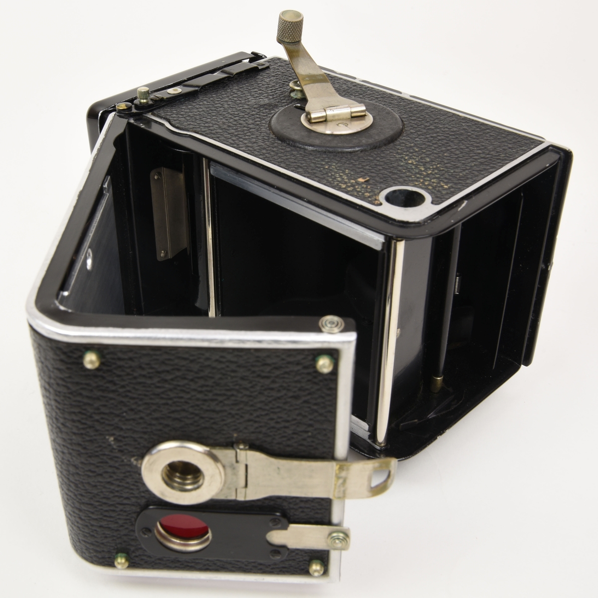 En tvåögd spegelreflexkamera av typen Rolleiflex (:1) med tillhörande beredskapsväska gjord av brunt läder (:2).

Det översta objektivet (som används för att komponera bilden) i kameran är ett Heidoscop-Anastigmat 75mm f 3,1. Det nedersta objektivet som används för att ta själva bilden är ett Carl Zeiss Jena modell Tessar 75mm f 3,5. Kameran är gjord i metall och är dekorerad med konstläder / läderimitation.

Den bruna beredskapsväskan (:2) har på baksidan ett fönster av gulnad plast som är till för att kunna läsa exponeringstabellen på kamerans baksida.

Kameran tar 120 film.