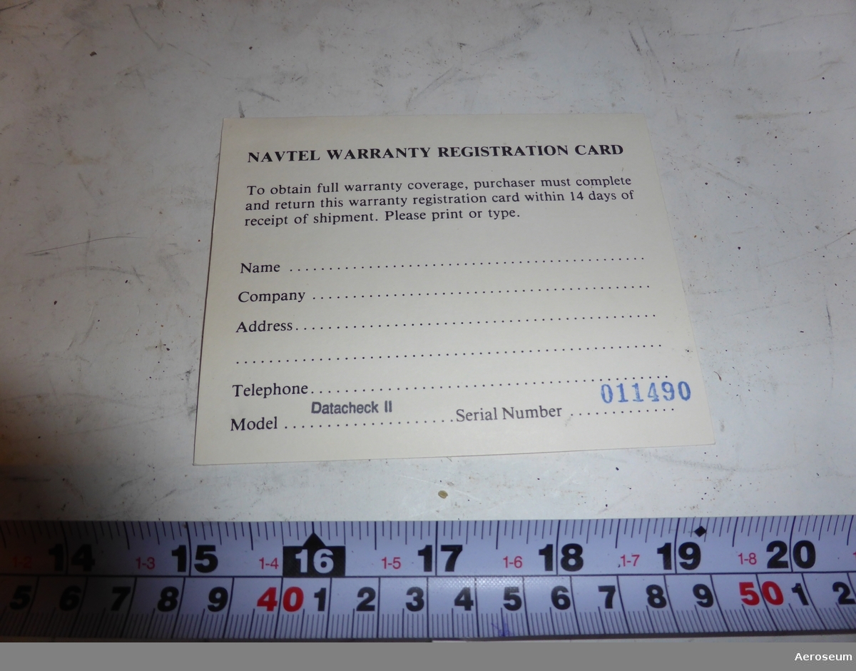 En pappkartonglåda med ett gränssnittprovdon för datakommunikation i. I lådan finns även en bruksanvisning, och ett papper där det står: "Navtel warranty registration card".